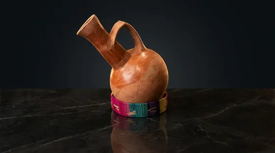 Terracotta Eritrean jebena on a woven ring stand