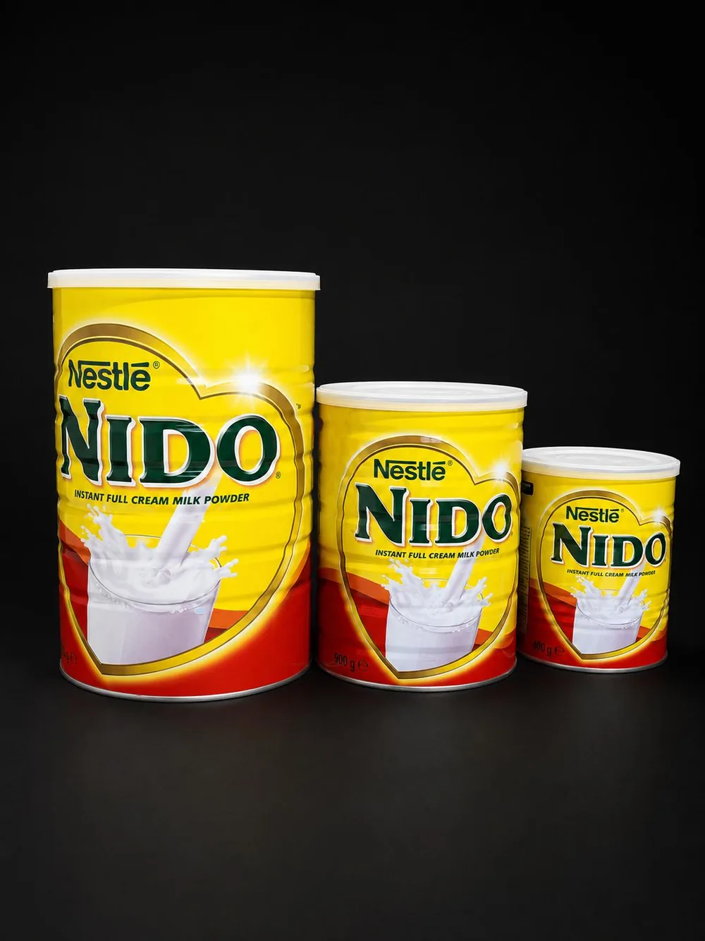 Three tins of Nestlé NIDO instant full cream milk powder in different sizes